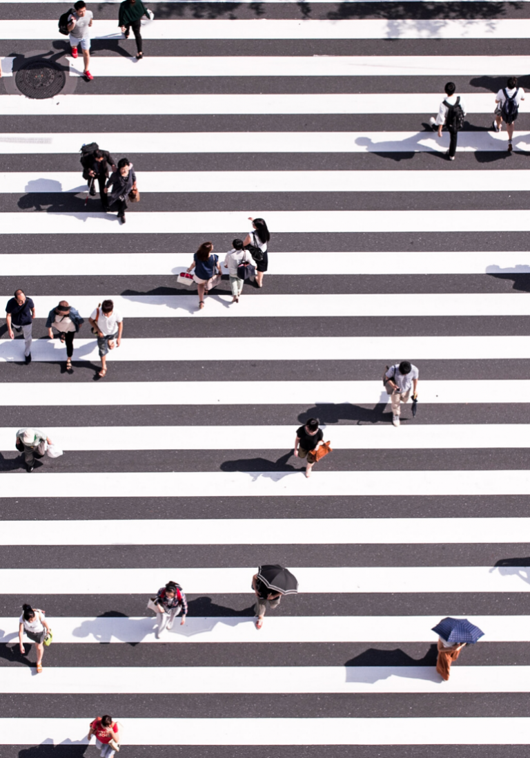 Sur cette image, on aperçoit un très grand piéton avec des individus la traversant.