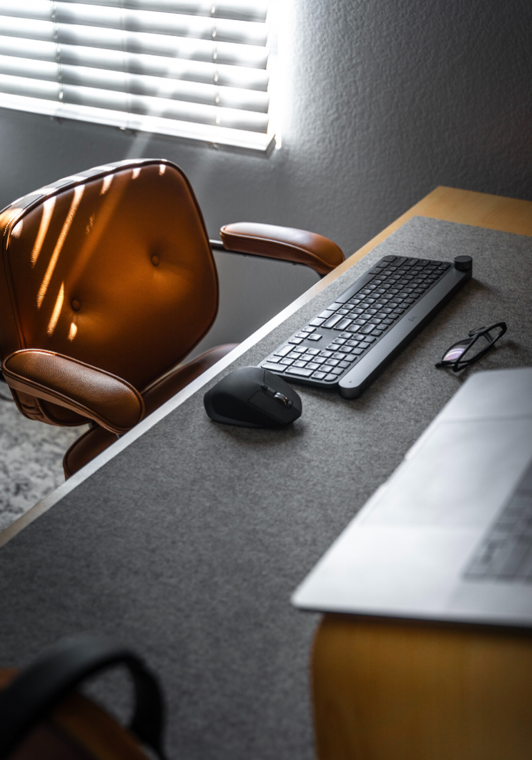 Sur cette image nous sommes dans un bureau, nous apercevons dans une lumière calme, une table, un ordinateur, un clavier, une chaise.