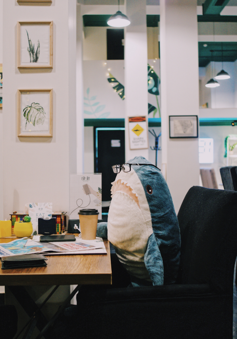 In this photo, we are in a workspace, we see an office with things or even coffee.