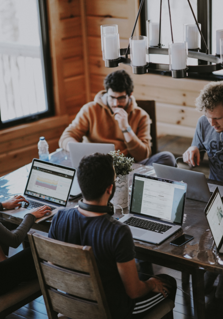 In this photo, we see colleagues working and discussing around a table